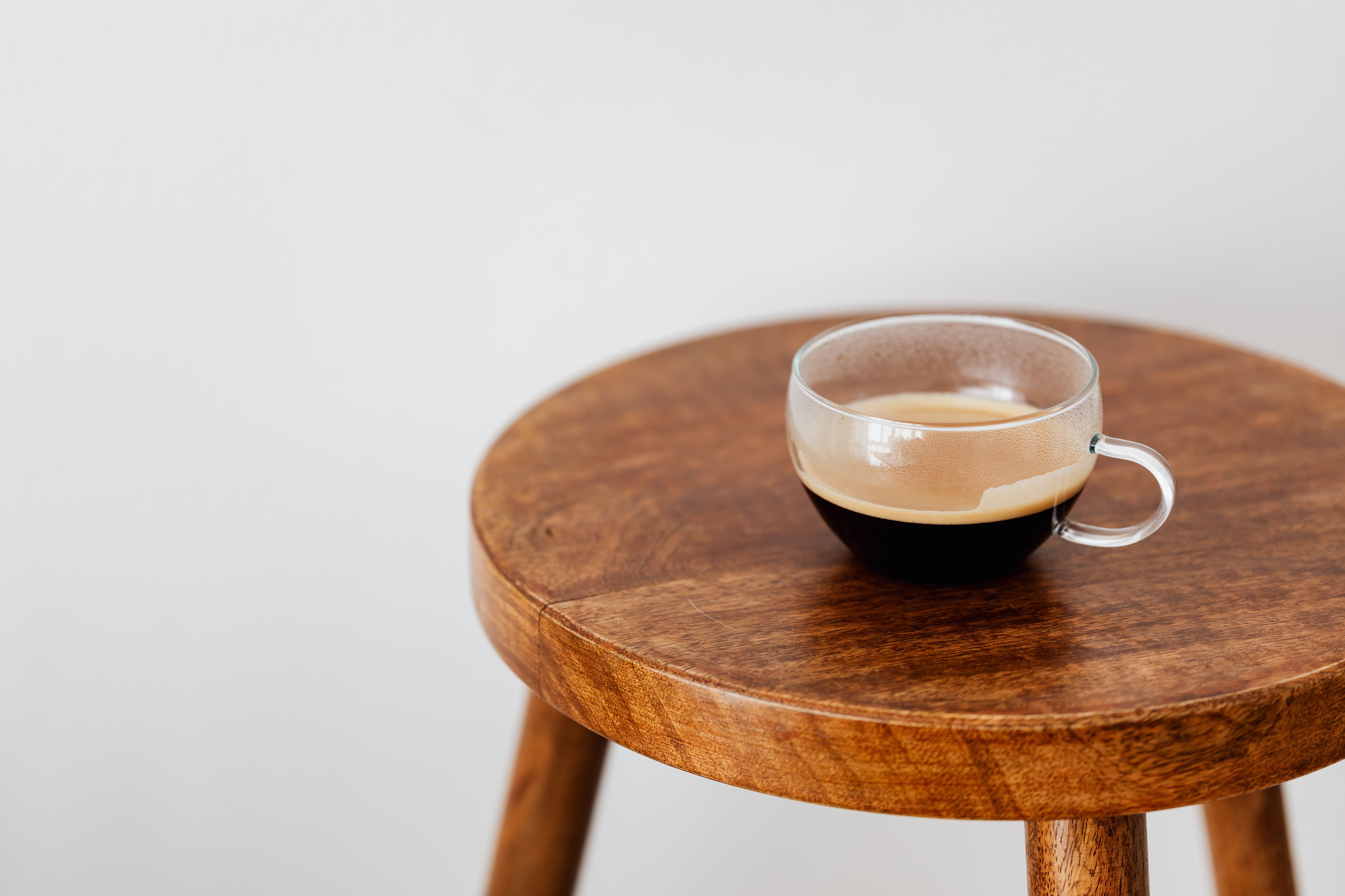 Coffee in a glass cup on a wooden table.